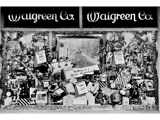 Black and white photo of a Walgreen Co. store window decorated for Christmas.